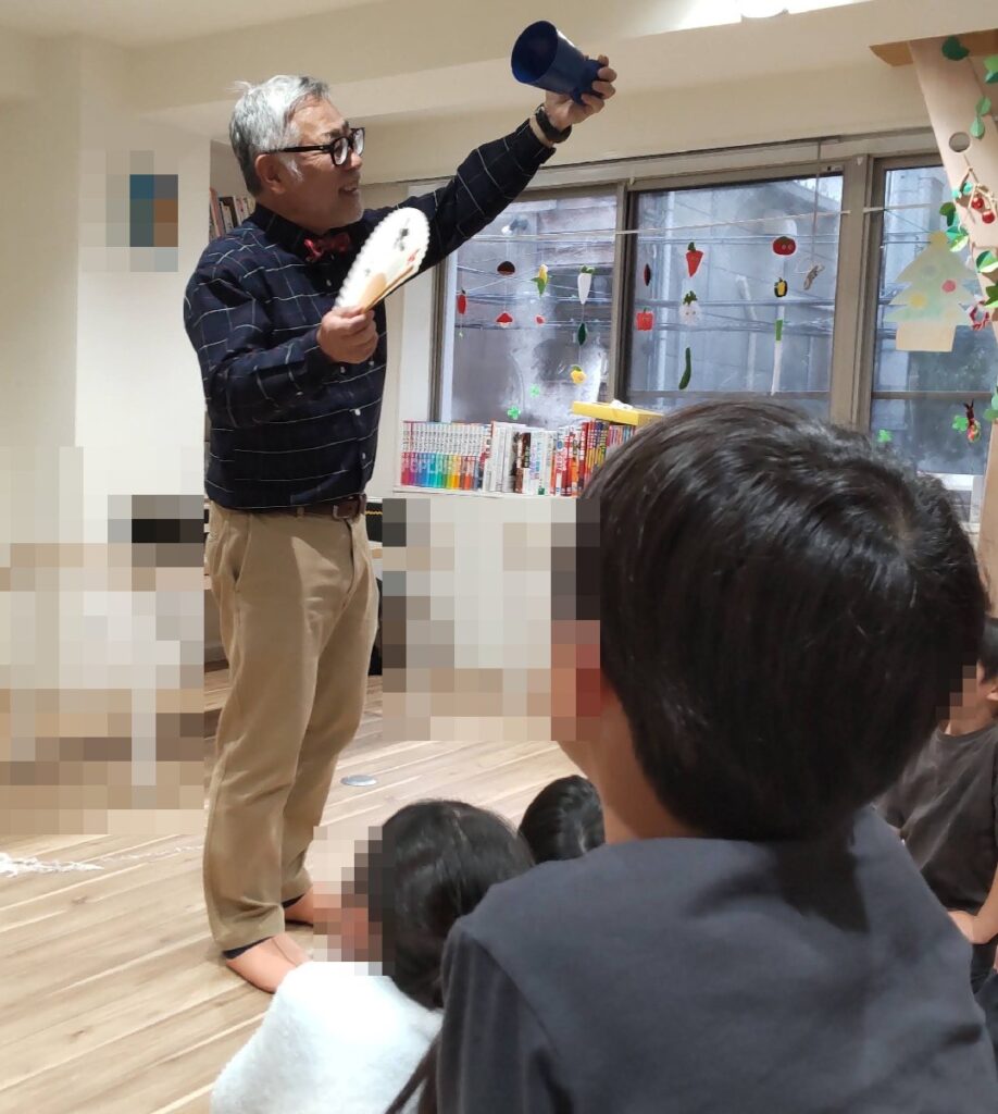 大阪市北区の学童保育でのボランティア・マジックショー。紙うどんというマジックの最後のオチで、桜吹雪を散らしています。