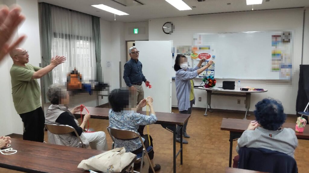 大阪の西区の広教会館でのボランティア・マジックショー。写真は、マジック教室で覚えたマジックを披露して見事に成功させたお客さんです。