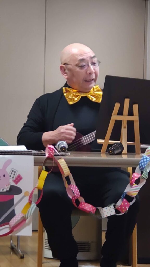 大阪吹田市の老人施設でのボランティア・マジックショー。ウクレレで、楽しい歌を歌っているところです。