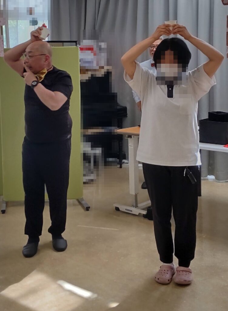 大阪の老人施設でのボランティア・マジックショー。頭の上のカップの水がいつのまにか消えてしまうマジックです。