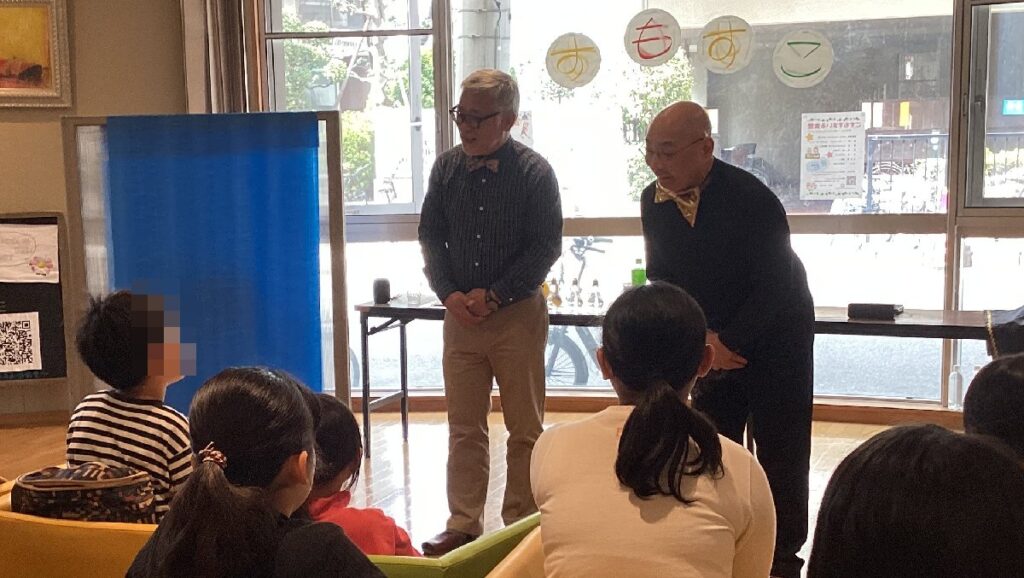 大阪の子ども食堂でのボランティア・マジックショー。マジックを楽しむためのコツを話しているところ。