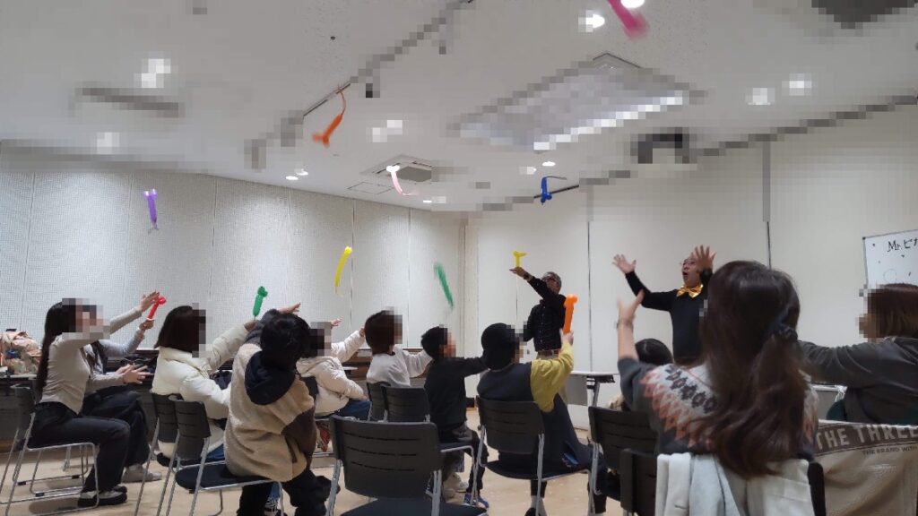 大阪市城東区の母子家庭の集まりで、ボランティア・マジックショーをさせていただきました。写真は、バルアートのロケットネズミを作って飛ばす体験をしているところです。