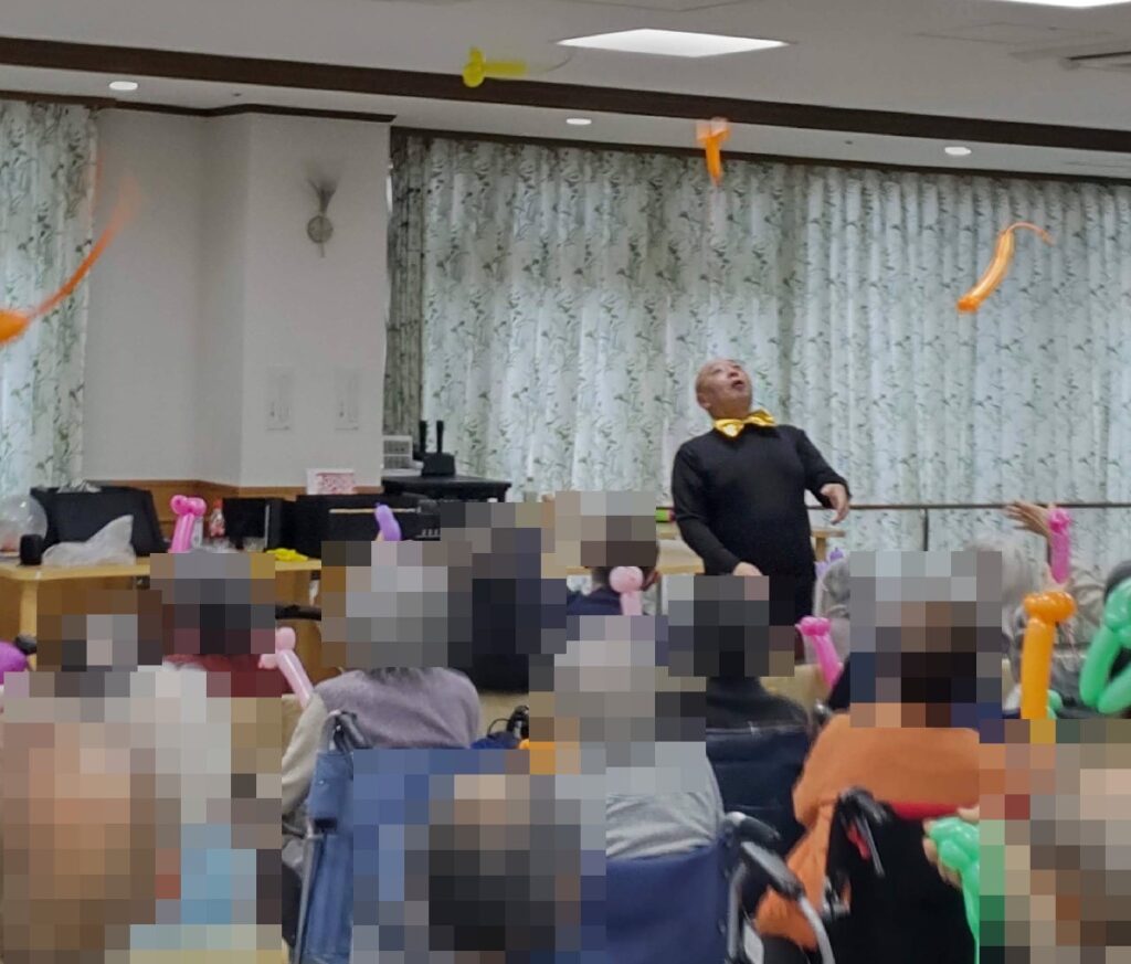 大阪鶴見区の老人施設でのボランティア・マジックショー。バルアートのロケットネズミを作って飛ばす遊びを体験していただきました。
