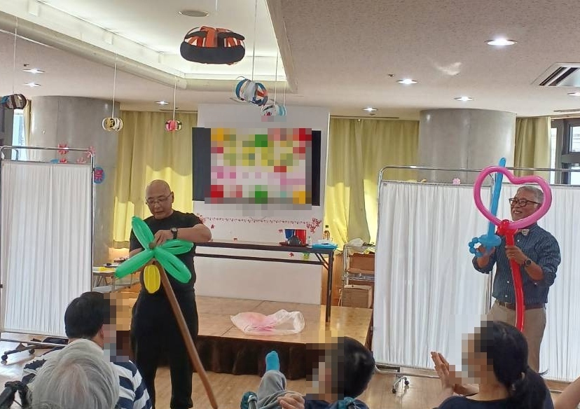 大阪の老人施設でのボランティア・マジックショー。目の前でバルーンアートを作るパフォーマンスをしています。