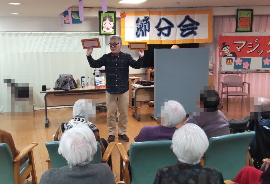 大阪都島区の老人施設でのボランティア・マジックショー。平べったいパネルからコップが出現するマジックです。