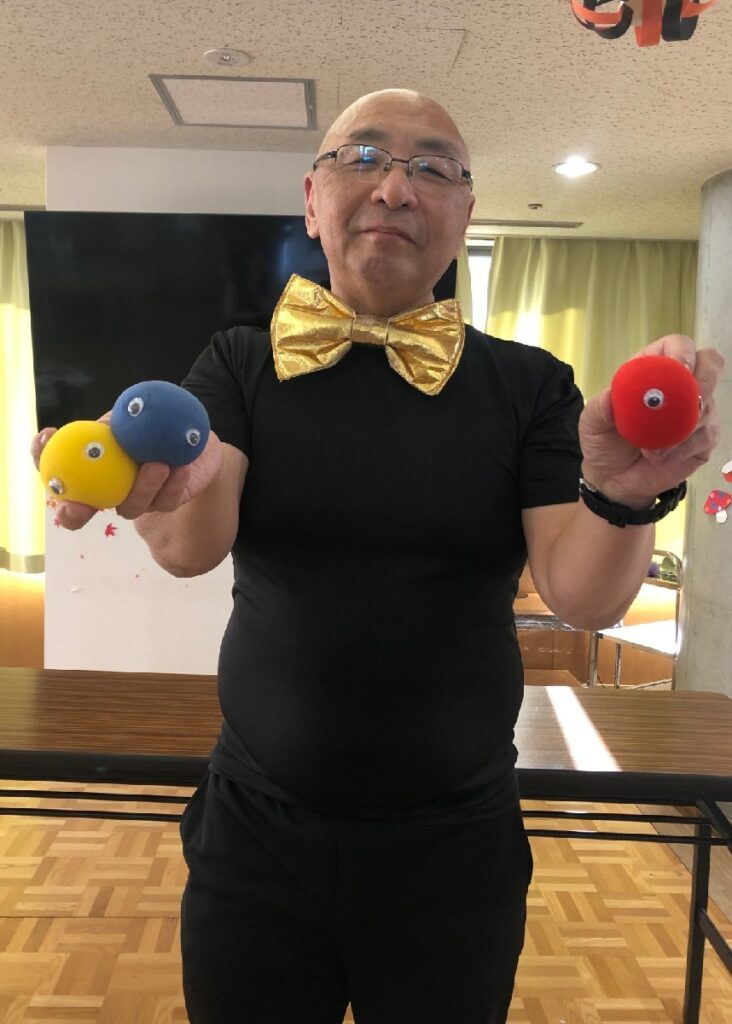 大阪の都島区のNPO法人の 大人食堂でのマジックショー。ピカリンがメンタルボールというマジックを披露しているところです。