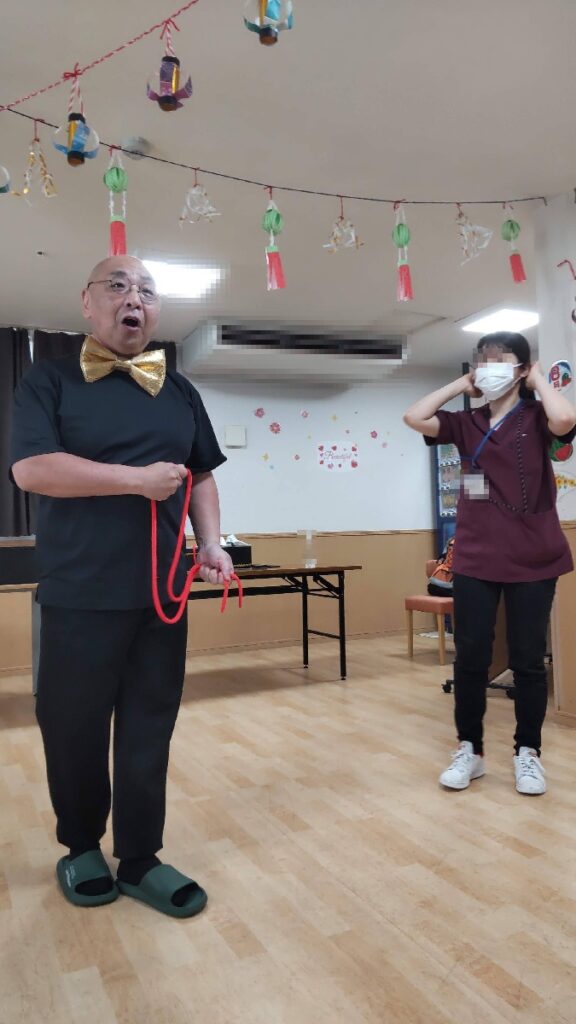 大阪旭区のサービス付き高齢者向け住宅でのボランティア・マジックショー。ピカリンが驚きのロープマジックを披露しているところです。