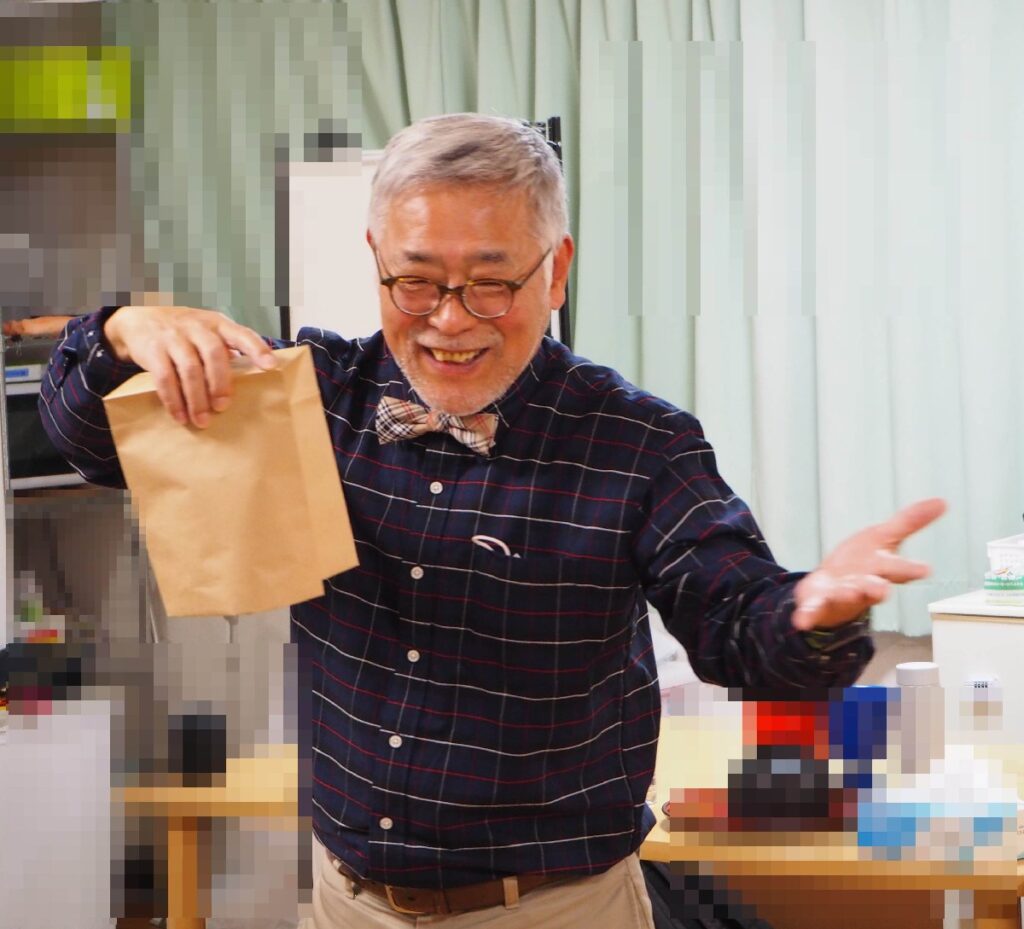 大阪の老人施設でのボランティア・マジックショー。袋の中に水の入ったコップを入れて、ひっくり返しますが、コップも水も落ちてきません。不思議な水のマジックです。